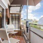 Terrace with seating, umbrella, and view of residential house