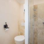 Bathroom with shower, toilet, and toilet paper holder.