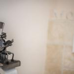 Toilet paper holder with metal figure on wall