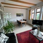 Wohnraum mit moderner Essecke, Flachbildschirm und gemütlicher Sitzecke.