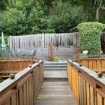 Über eine kleine Brücke erreichen Sie die ruhig gelegene Terrasse direkt am Waldrand.