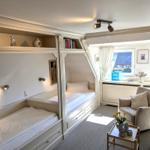 Zimmer mit zwei Betten, Sitzgelegenheit und Fensterblick.