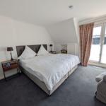 Bedroom with double bed, closet, and window with curtains.