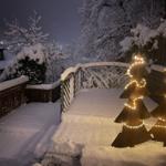 Die Terrasse liegt still und verschneit in der Winterlandschaft.