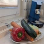 Auf dem Tisch liegen rote Paprika, Karotte, Zucchini und Käse.