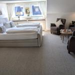 Schlafzimmer mit Doppelbett, Sitzbereich und Fenster
