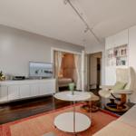Wohnzimmer mit Sofa, Sessel, Couchtisch und Fernseher.