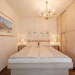 Schlafzimmer mit Doppelbett, Kleiderschrank und Kronleuchter.