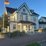 Strenghotel mit Eingang, Flagge und gepflastertem Weg.