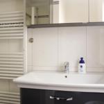 Badezimmer mit Waschbecken, Spiegelschrank und Heizkörper