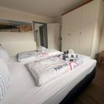Schlafzimmer mit Bett, Kleiderschrank und Stuhl.
