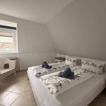 Schlafzimmer mit Doppelbett, Nachttischen und Fenster.