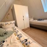 Zwei Betten mit Strandmotiv in einem Dachzimmer mit Holzboden und Fenster.