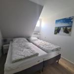 Bedroom with double bed, window, and wall picture.
