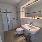 Badezimmer mit Dusche, Waschbecken und Toilette.