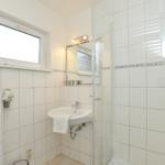 Badezimmer mit Dusche, Waschbecken und Fenster