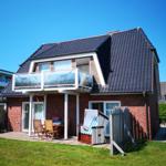 Zwei-Schichten-Haus mit Balkon, Terrasse und Strandkorb.