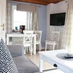 Living and dining area with sofa, table, chairs, and TV.