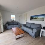 Living room with two sofas, wooden table, and wall art.