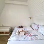 Bedroom with bed, pillows, and nightstand under sloped walls.