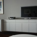 TV auf weißem Sideboard mit Projektor und Bild an der Wand