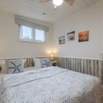 Schlafzimmer mit Bett, Nachttischen und Wandbildern