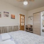 Schlafzimmer mit Bett, Kleiderschrank und Wandbildern