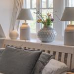 Bedroom with bed, window, and decorative lamps on windowsill.