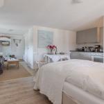 Bedroom with kitchen area and living space in a vacation home.