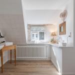 Bathroom with wooden floor, sink, and window