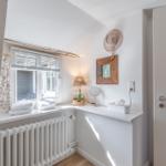 Bathroom with window, radiator, and decorative items on the wall.