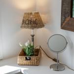 Table lamp with basket and mirror on white counter