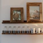 Wall shelf with pictures, glasses, and mugs with rabbit motif.