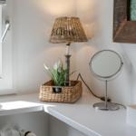 Bathroom with window, lamp, mirror, and flowers in basket