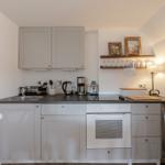 Kitchen with white cabinets, stove, and worktop.