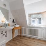 Bathroom with shower, sink, and window