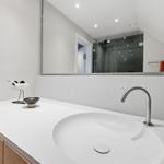 Badezimmer mit Waschbecken, Spiegel und Dusche