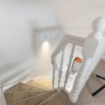 Weiße Treppe mit Teppich und Geländer im Haus