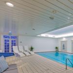 Indirektes Licht erhellt den Poolbereich mit Liegestühlen und Wandbildern.