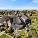 Dorfhaus mit Strohdach, Garten und Meerblick.