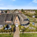 Dorfhaus mit Strohdach, Garten und Blick aufs Meer.
