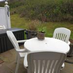 Runder Tisch mit Stühlen und Pflanzen auf Terrasse
