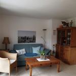 Wohnzimmer mit Sofa, Holztisch und Sideboard.