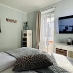 Hauptschlafzimmer mit direktem Zugang zum West-Teakholzbalkon mit Strandkorb und Teakholzmöbel.