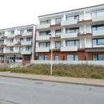 Modernes Mehrfamilienhaus mit Balkonen und Fenstern
