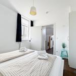 Schlafzimmer mit Doppelbett, Fenster und Kleiderschrank.