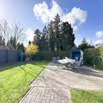 Hinterhof mit Terrasse, Garten, Tisch, Stühlen und Strandkorb.