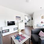 Wohn- und Essbereich mit Küche. Sofa, Couch, TV und Esstisch.