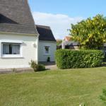 House with garden, green lawn, and flowering tree