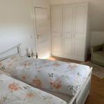Bedroom with double bed, wardrobe, and armchair.
